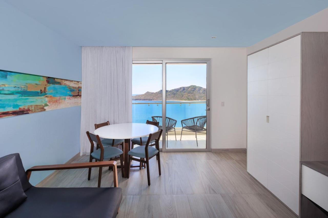 Suite de 1 dormitorio con cama extrangrande, balcón y vistas al mar